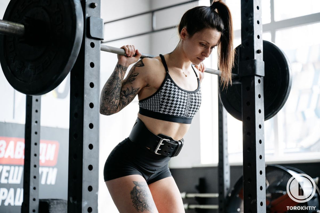 Haciendo sentadillas con un cinturón de gimnasia para mujeres