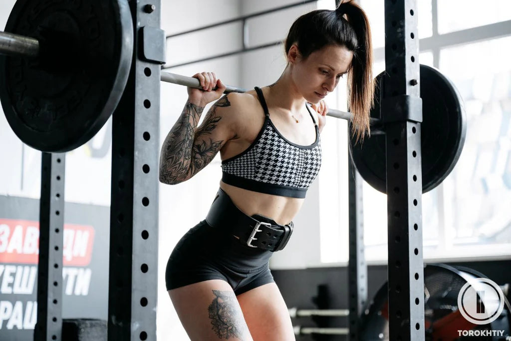 Haciendo sentadillas con un cinturón de gimnasia para mujeres