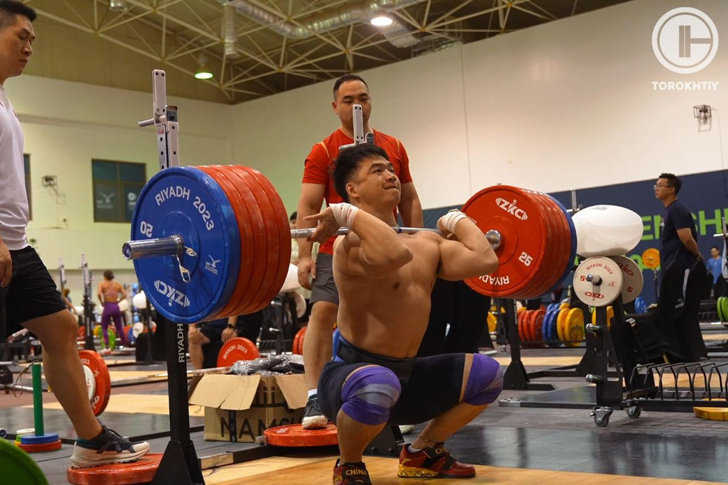 Chinese weightlifter performing clean and jerk exercise