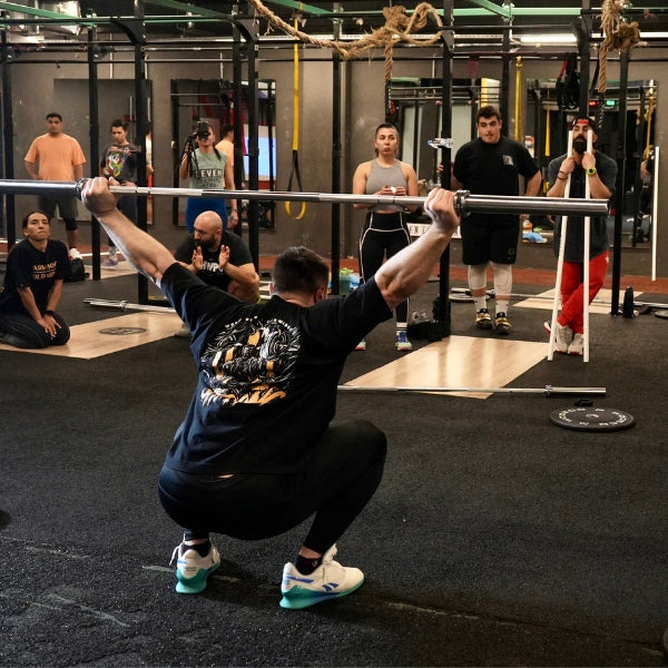 Coach Oleksiy Torokhtiy demonstrates squat technique using a barbell at a seminar (Torokhtiy Weightlifting)